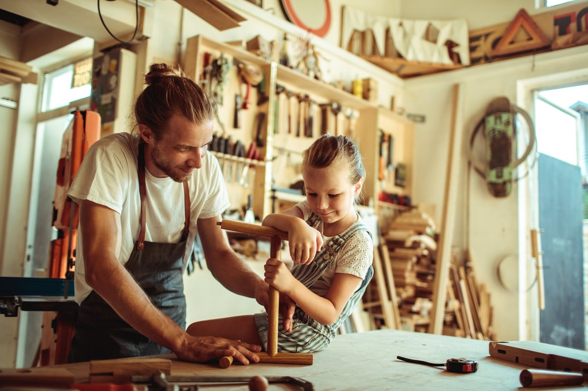 Close up of a father showing his daughter carpentry — local artisan focused on creating handmade products