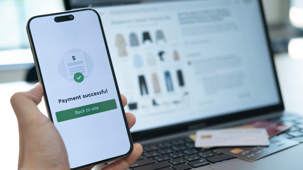 Holding a phone with payment success displayed, and a credit card placed below, highlighting the convenience of cashless payment systems
