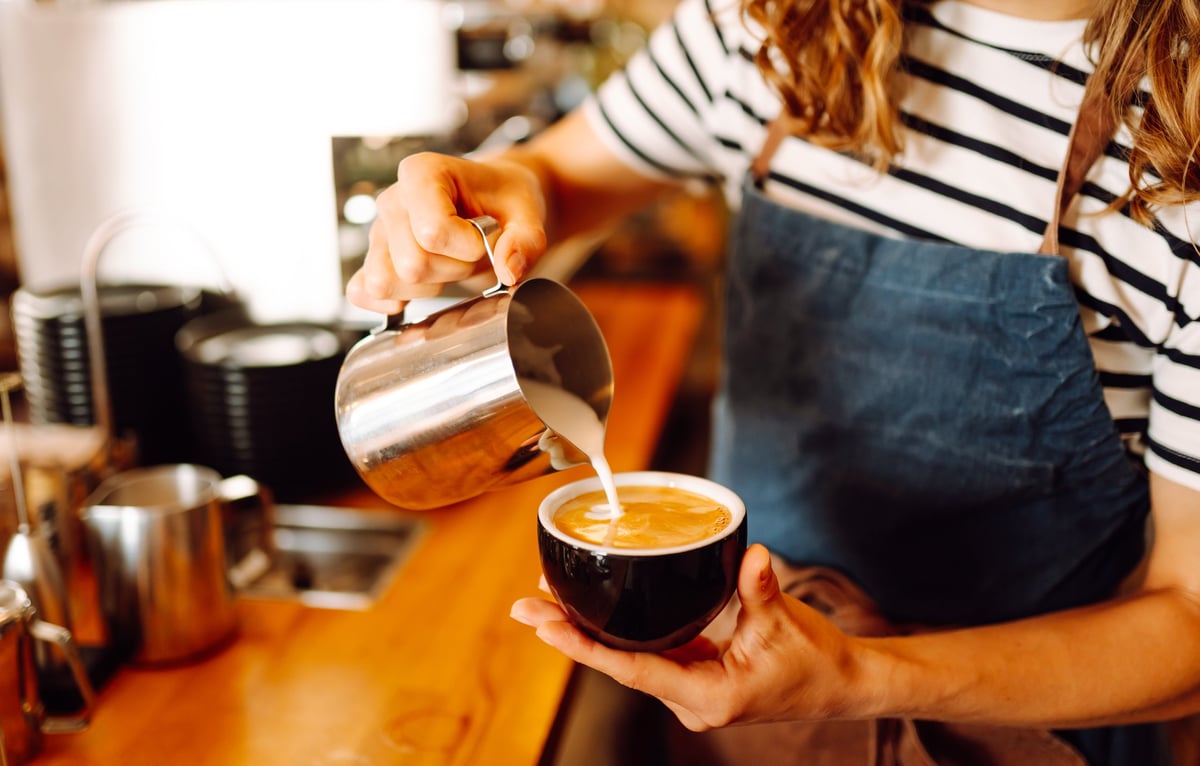 Experienced barista preparing coffee in a cosy café — a clear brand is often felt in simple, everyday details