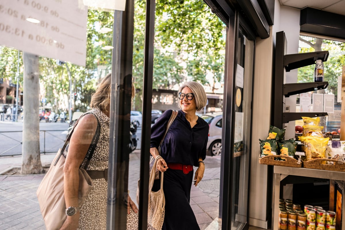 Two cheerful people exiting a city store — a welcoming business front that attracts attention but the experience behind the door does the real work