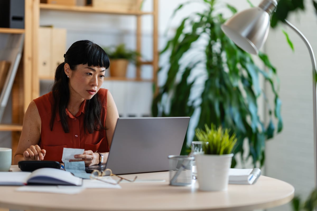 Small business owner working on laptop at home office — managing digital presence and online visibility