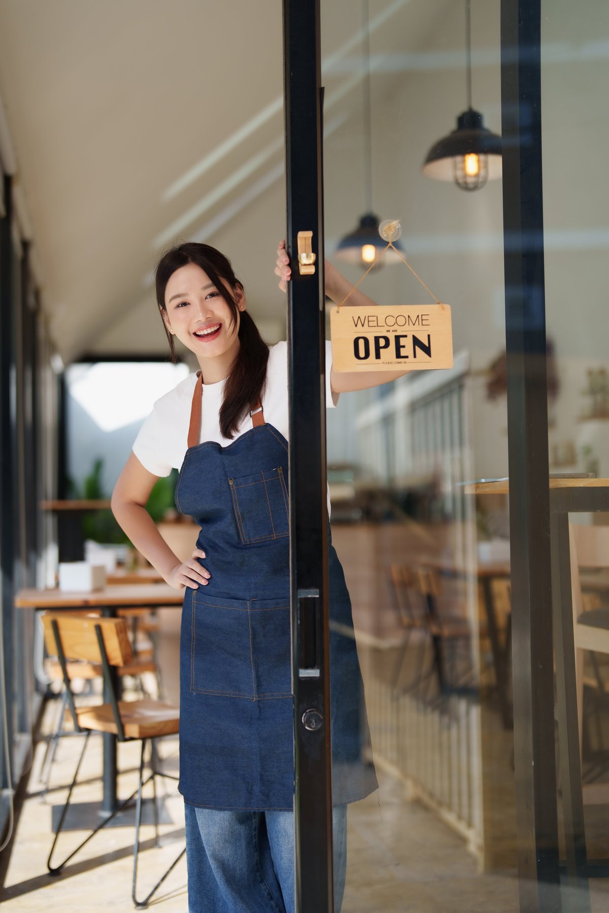 Small business owner standing in shop doorway welcoming customers — a clear online presence starts with making the business easy to recognise and trust