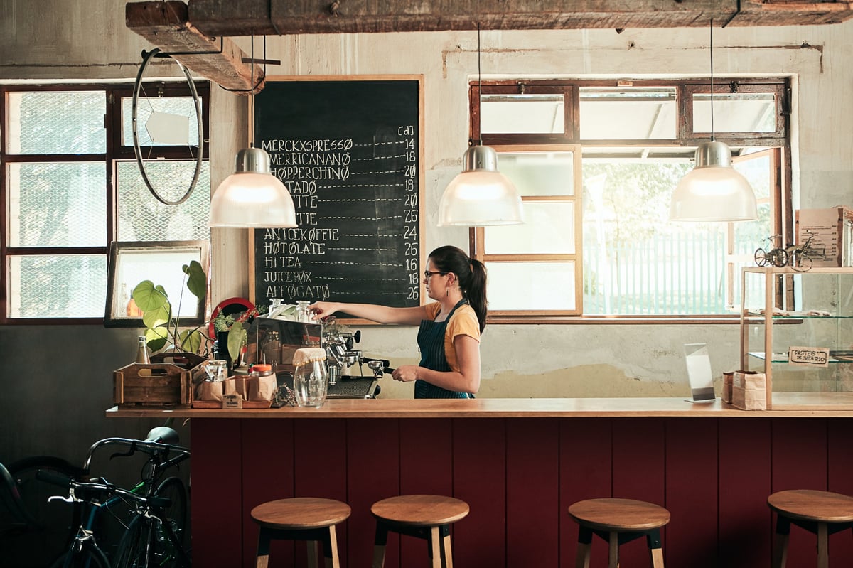 Barista working in the restaurant under new brand signage